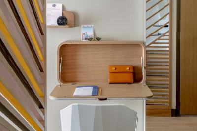 Lavabo moderne avec miroir rond, étagère murale, robinet chromé et panneaux en bois ajourés en premier plan.