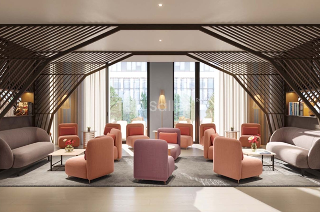 Espace lounge moderne avec fauteuils roses, canapés gris, tables basses et grandes fenêtres laissant entrer la lumière…