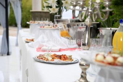Lettres rouges formant le mot ’LOVE’ sur un tapis rouge, entourées de petites décorations blanches, en extérieur.