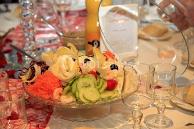 Lettres rouges formant le mot ’LOVE’ sur un tapis rouge, entourées de petites décorations blanches, en extérieur.