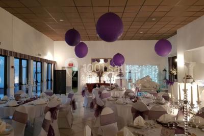 Lettres rouges formant le mot ’LOVE’ sur un tapis rouge, entourées de petites décorations blanches, en extérieur.