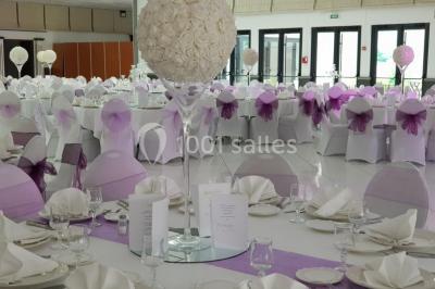 Lettres rouges formant le mot ’LOVE’ sur un tapis rouge, entourées de petites décorations blanches, en extérieur.