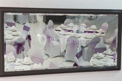 Lettres rouges formant le mot ’LOVE’ sur un tapis rouge, entourées de petites décorations blanches, en extérieur.