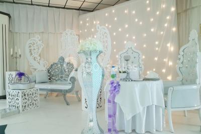 Lettres rouges formant le mot ’LOVE’ sur un tapis rouge, entourées de petites décorations blanches, en extérieur.