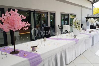 Lettres rouges formant le mot ’LOVE’ sur un tapis rouge, entourées de petites décorations blanches, en extérieur.