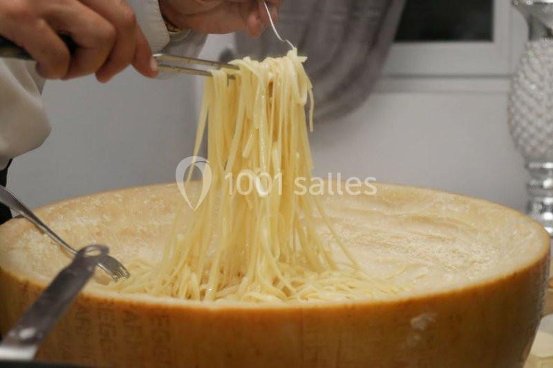 Des pâtes chaudes sont mélangées dans une meule de fromage, créant une sauce fondante.