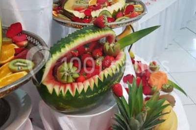 Lettres rouges formant le mot ’LOVE’ sur un tapis rouge, entourées de petites décorations blanches, en extérieur.