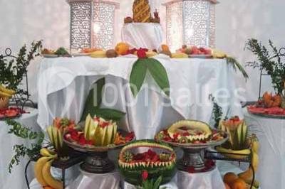 Lettres rouges formant le mot ’LOVE’ sur un tapis rouge, entourées de petites décorations blanches, en extérieur.