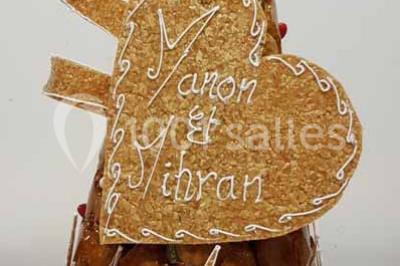 Lettres rouges formant le mot ’LOVE’ sur un tapis rouge, entourées de petites décorations blanches, en extérieur.