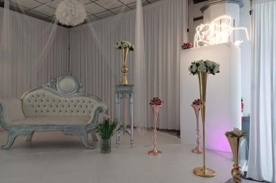 Lettres rouges formant le mot ’LOVE’ sur un tapis rouge, entourées de petites décorations blanches, en extérieur.