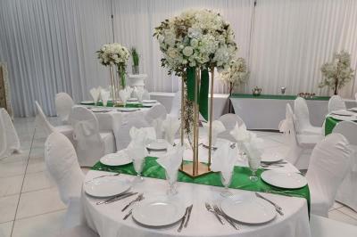 Lettres rouges formant le mot ’LOVE’ sur un tapis rouge, entourées de petites décorations blanches, en extérieur.