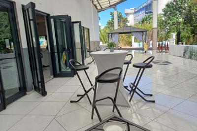 Lettres rouges formant le mot ’LOVE’ sur un tapis rouge, entourées de petites décorations blanches, en extérieur.