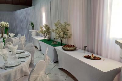 Lettres rouges formant le mot ’LOVE’ sur un tapis rouge, entourées de petites décorations blanches, en extérieur.