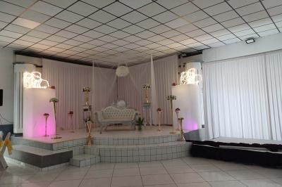 Lettres rouges formant le mot ’LOVE’ sur un tapis rouge, entourées de petites décorations blanches, en extérieur.