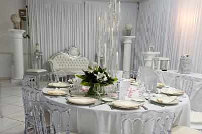 Lettres rouges formant le mot ’LOVE’ sur un tapis rouge, entourées de petites décorations blanches, en extérieur.