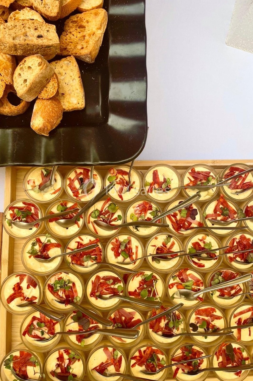 Plateau de verrines garnies de crème et légumes, accompagné d'un plat de tranches de pain grillé.