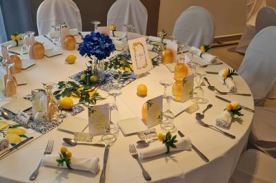 Table décorée pour une fête avec des donuts glacés bleus, des cubes décoratifs et des desserts variés sur des supports en…