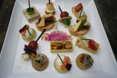 Miniature Traiteur Magny-en-Vexin (Val-d'Oise) - Karen Réceptions Organisation #6 Corbeille garnie de fruits variés et fleurs décoratives, posée sur une table dans un environnement faiblement éclairé.