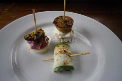 Miniature Traiteur Magny-en-Vexin (Val-d'Oise) - Karen Réceptions Organisation #7 Corbeille garnie de fruits variés et fleurs décoratives, posée sur une table dans un environnement faiblement éclairé.