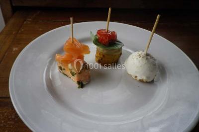 Miniature Traiteur Magny-en-Vexin (Val-d'Oise) - Karen Réceptions Organisation #8 Corbeille garnie de fruits variés et fleurs décoratives, posée sur une table dans un environnement faiblement éclairé.