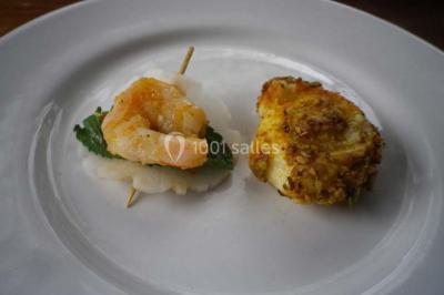 Miniature Traiteur Magny-en-Vexin (Val-d'Oise) - Karen Réceptions Organisation #10 Corbeille garnie de fruits variés et fleurs décoratives, posée sur une table dans un environnement faiblement éclairé.