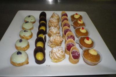 Miniature Traiteur Magny-en-Vexin (Val-d'Oise) - Karen Réceptions Organisation #26 Corbeille garnie de fruits variés et fleurs décoratives, posée sur une table dans un environnement faiblement éclairé.