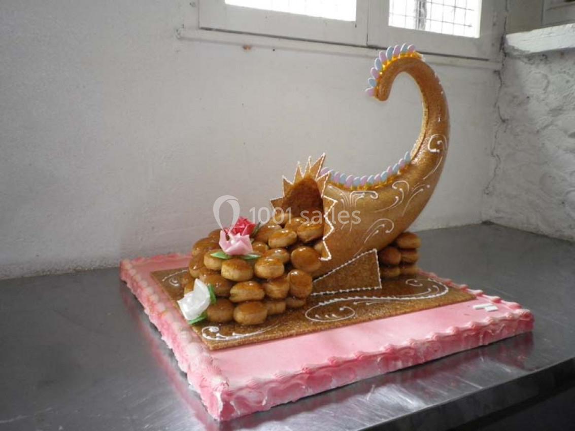 Pièce montée en forme de corne d'abondance, composée de choux caramélisés et décorée de fleurs en sucre.