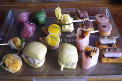 Miniature Traiteur Magny-en-Vexin (Val-d'Oise) - Karen Réceptions Organisation #3 Corbeille garnie de fruits variés et fleurs décoratives, posée sur une table dans un environnement faiblement éclairé.