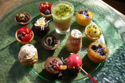 Miniature Traiteur Magny-en-Vexin (Val-d'Oise) - Karen Réceptions Organisation #20 Corbeille garnie de fruits variés et fleurs décoratives, posée sur une table dans un environnement faiblement éclairé.