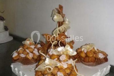 Miniature Traiteur Magny-en-Vexin (Val-d'Oise) - Karen Réceptions Organisation #29 Corbeille garnie de fruits variés et fleurs décoratives, posée sur une table dans un environnement faiblement éclairé.