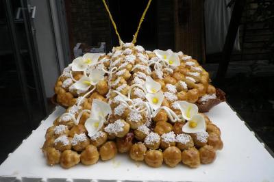 Miniature Traiteur Magny-en-Vexin (Val-d'Oise) - Karen Réceptions Organisation #27 Corbeille garnie de fruits variés et fleurs décoratives, posée sur une table dans un environnement faiblement éclairé.