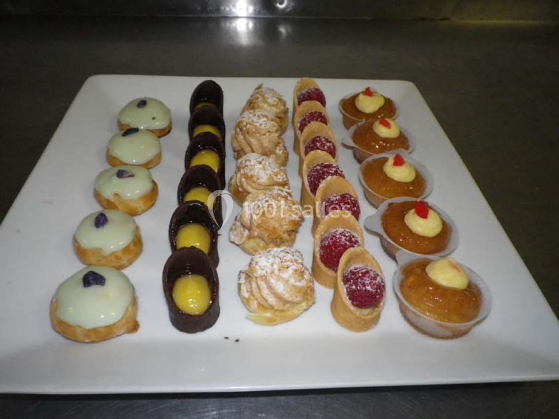 Plateau de pâtisseries variées disposées en rangées, incluant éclairs, tartelettes et choux garnis.