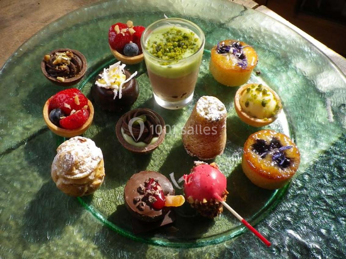 Assortiment de petits desserts variés présentés sur une assiette en verre transparent.