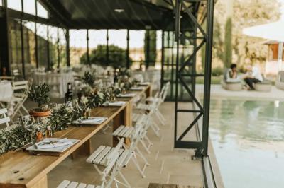 Miniature Traiteur Aix-en-Provence (Bouches-du-Rhône) - Carré Gourmand #20 Table dressée avec nappes blanches, verres à vin, couverts, petits pains et centre de table floral dans une salle lumineuse.