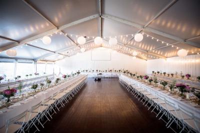 Miniature Traiteur Aix-en-Provence (Bouches-du-Rhône) - Carré Gourmand #21 Table dressée avec nappes blanches, verres à vin, couverts, petits pains et centre de table floral dans une salle lumineuse.