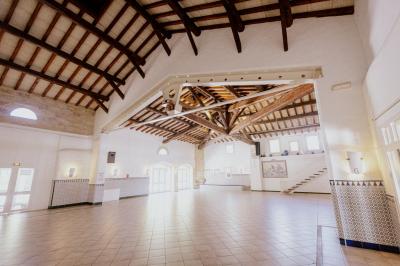 Miniature Location salle Marsillargues (Hérault) - Le Mas Saint Gabriel #7 Une mariée souriante brandit un éventail devant un gâteau de mariage décoré, entourée d'invités en extérieur.