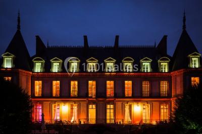 Manoir ancien entouré d'arbres et de buissons sous la neige, éclairé par une lumière hivernale douce.