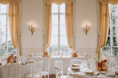 Manoir ancien entouré d'arbres et de buissons sous la neige, éclairé par une lumière hivernale douce.