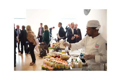 Groupe de personnes en vêtements d'hiver rassemblées dans une pièce éclairée par une lumière bleutée.