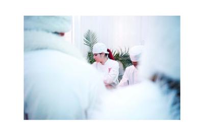 Groupe de personnes en vêtements d'hiver rassemblées dans une pièce éclairée par une lumière bleutée.