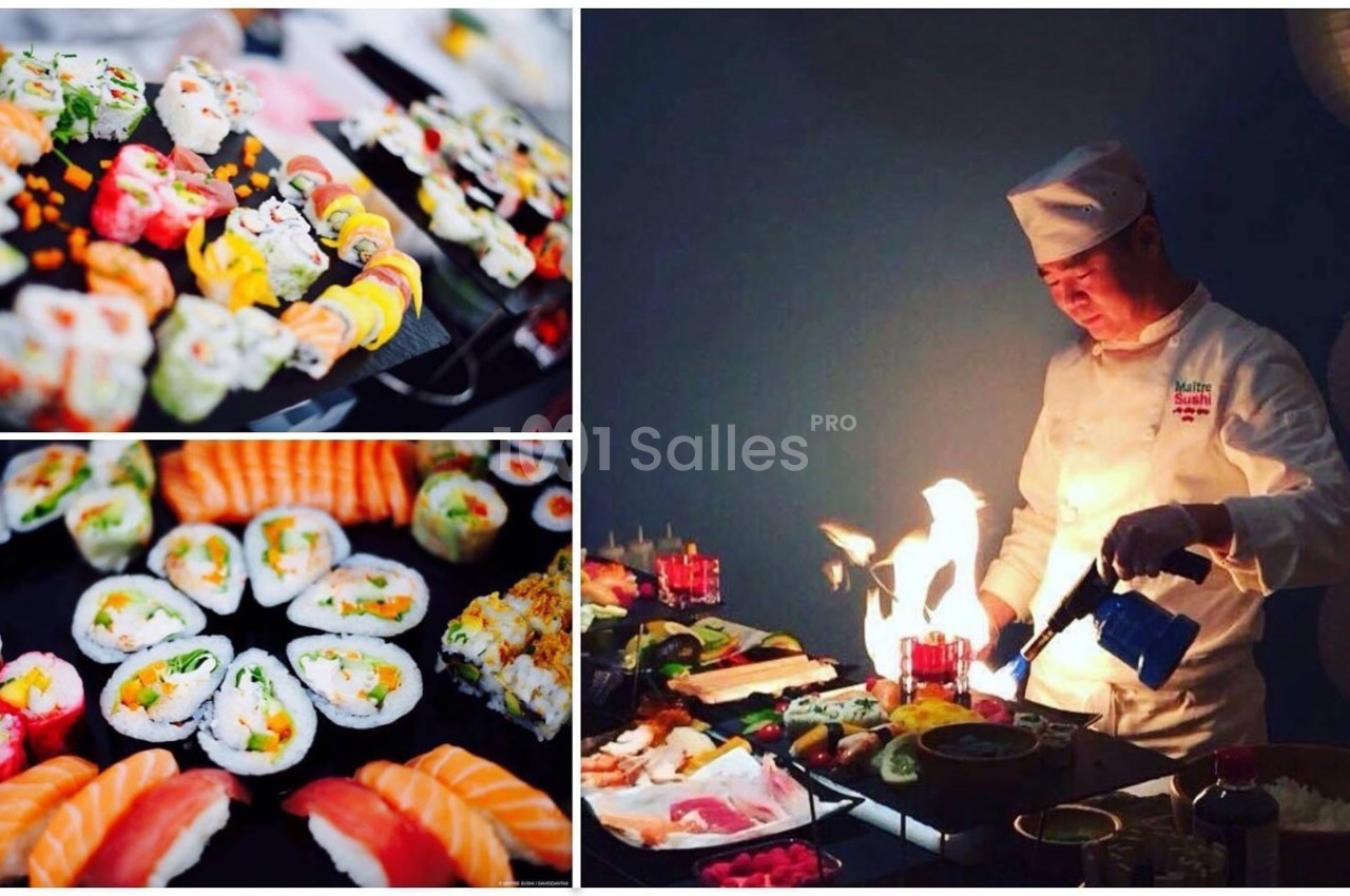 Un chef prépare des sushis variés avec un chalumeau, entouré de plateaux garnis de sushi et makis colorés.