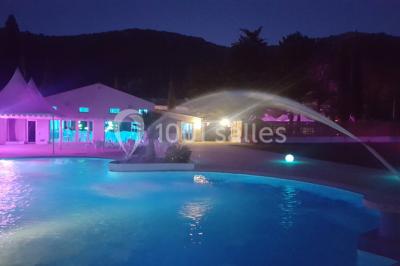Miniature Location salle Gémenos (Bouches-du-Rhône) - Le Domaine du Gem #18 Table dressée avec nappes blanches, verres et couverts, vue sur une terrasse avec piscine et chaises en arrière-plan.