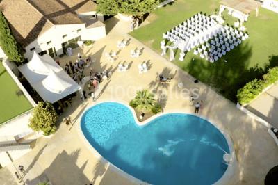 Miniature Location salle Gémenos (Bouches-du-Rhône) - Le Domaine du Gem #2 Table dressée avec nappes blanches, verres et couverts, vue sur une terrasse avec piscine et chaises en arrière-plan.