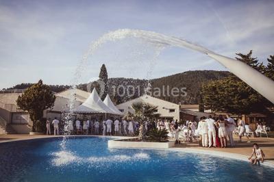 Miniature Location salle Gémenos (Bouches-du-Rhône) - Le Domaine du Gem #1 Table dressée avec nappes blanches, verres et couverts, vue sur une terrasse avec piscine et chaises en arrière-plan.