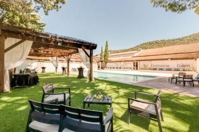 Miniature Location salle Gémenos (Bouches-du-Rhône) - Le Domaine du Gem #3 Table dressée avec nappes blanches, verres et couverts, vue sur une terrasse avec piscine et chaises en arrière-plan.