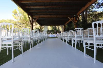 Miniature Location salle Gémenos (Bouches-du-Rhône) - Le Domaine du Gem #9 Table dressée avec nappes blanches, verres et couverts, vue sur une terrasse avec piscine et chaises en arrière-plan.