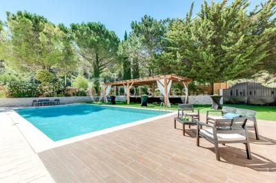 Miniature Location salle Gémenos (Bouches-du-Rhône) - Le Domaine du Gem #14 Table dressée avec nappes blanches, verres et couverts, vue sur une terrasse avec piscine et chaises en arrière-plan.