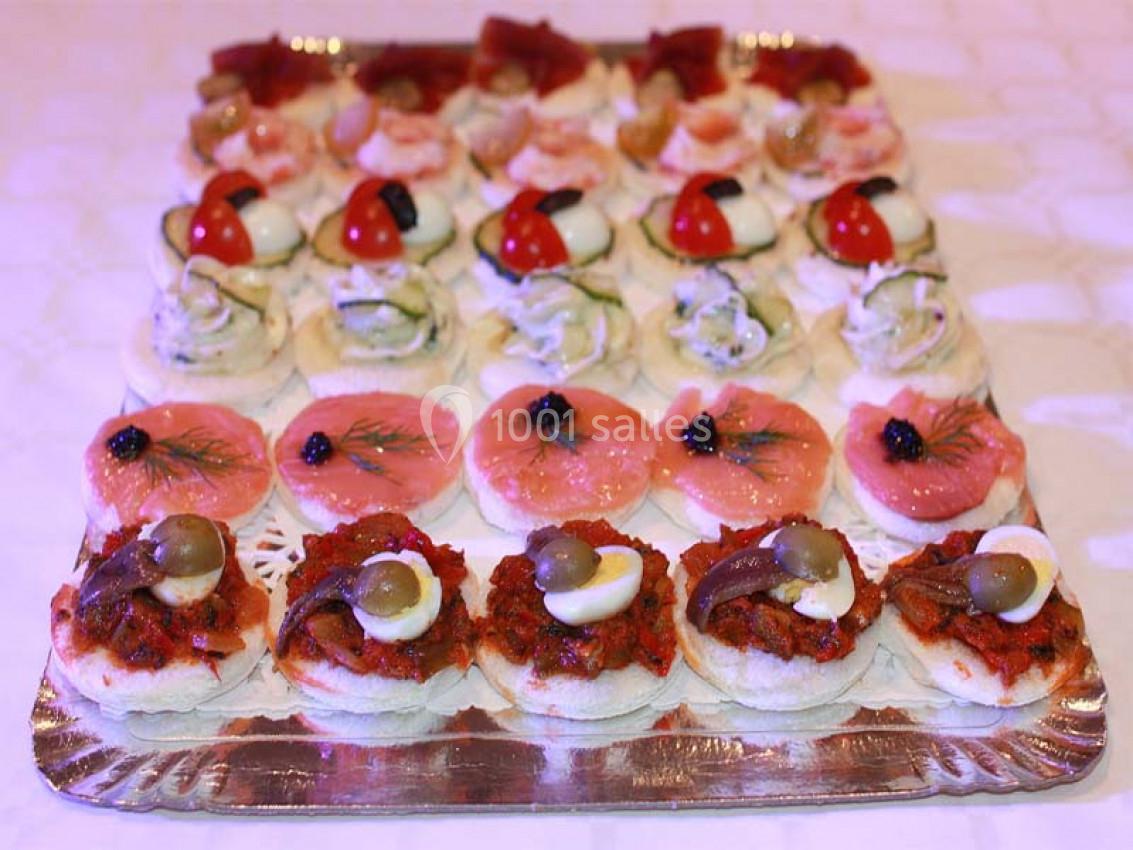 Plateau de canapés variés avec garnitures colorées, comprenant légumes, poissons, œufs et olives.