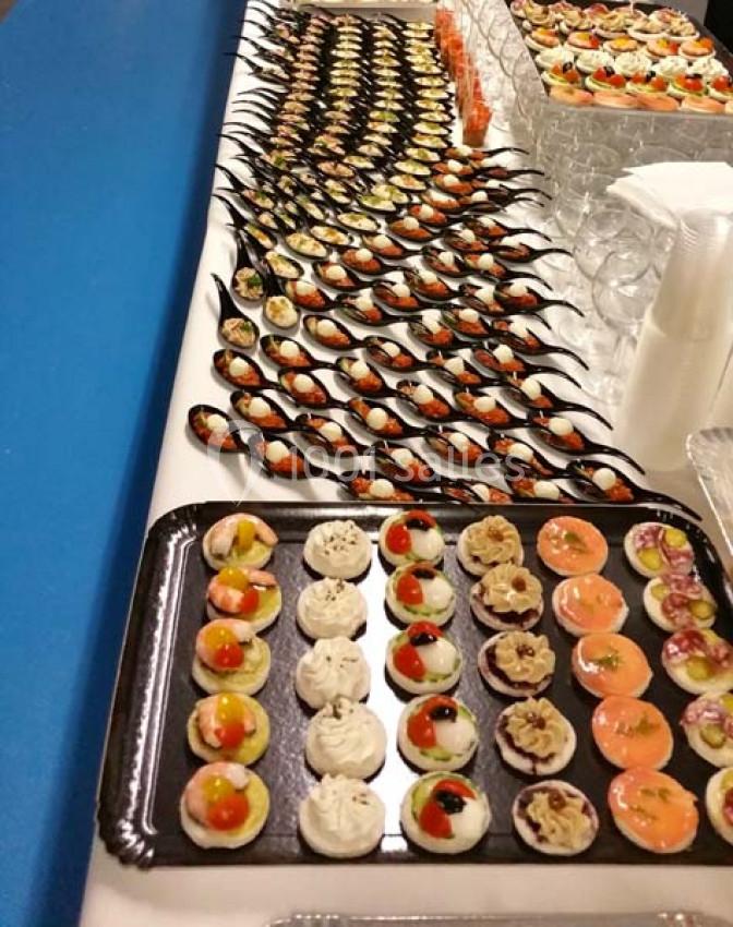 Plateau de canapés variés disposés sur une table, comprenant des bouchées salées et des cuillères apéritives.
