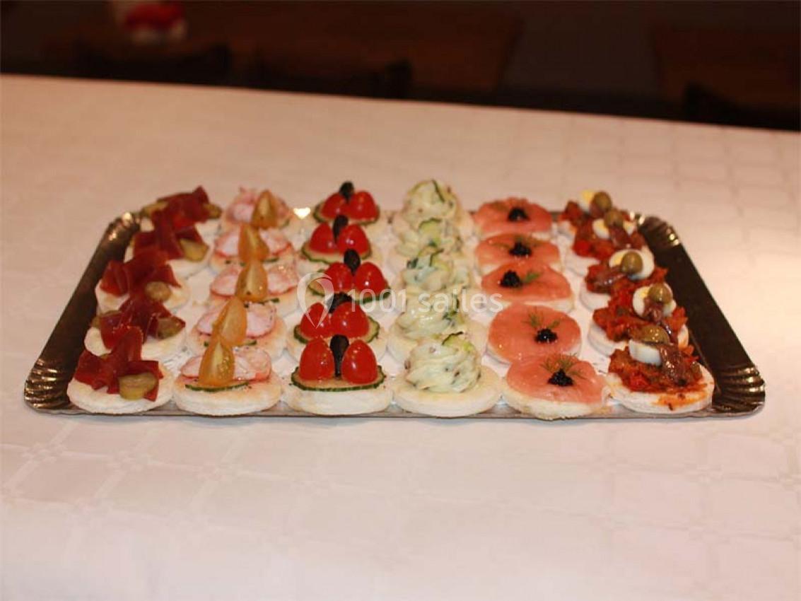 Plateau de canapés variés disposés en rangées, garnis de légumes, poissons et autres ingrédients colorés.